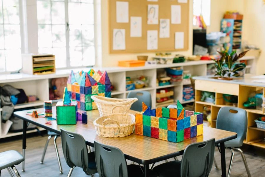 An empty classroom with geometric shape games and baskets on a child-size work table.